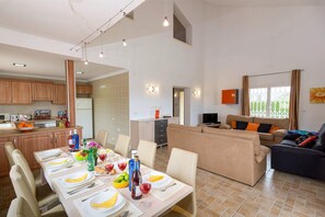 Un apartamento moderno con comedor, cocina, sala de estar y un balcón.