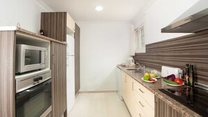 Eine kleine Küche mit Mikrowelle, Backofen und Spüle.