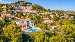A hillside residential area with a prominent white building featuring a swimming pool. - Villa Moggalatto by Villa Plus (Calp)