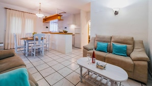 Una sala de estar con un sofá, una mesa de centro y un comedor con una mesa y sillas.