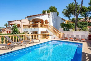 A hotel with a swimming pool, a two-story building with balconies, and a staircase leading to the upper floor. - Villa Naranja Blanca by Villa Plus (El Tosalet)