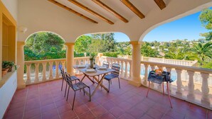 A covered outdoor patio with a table set for dining, chairs, and a grill. - Villa Rosa Blanca by Villa Plus (El Tosalet)