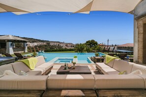 A pool area with a view of a town, outdoor seating, and a pergola. - Villa Silvasol by Villa Plus (Javea)