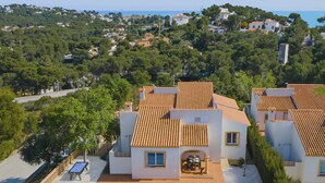 Un barrio residencial con casas, piscina y vistas al mar.