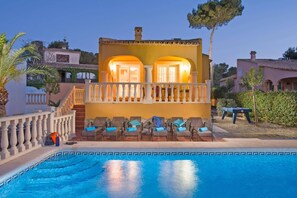A poolside area with lounge chairs and a pool.
