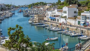 A marina with numerous boats docked along the waterfront, surrounded by buildings with white facades and red-tiled roofs. - Villa Aljub by Villa Plus (Ciutadella de Menorca)