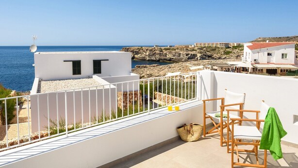 A terrace with a view of the sea, white buildings, and a rocky coastline. - Villa Amatista by Villa Plus (Los Delfines)