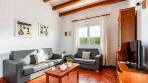 A living room with two grey sofas, a wooden coffee table, and a TV stand. - Villa Avellano by Villa Plus (Cap d'Artrutx)