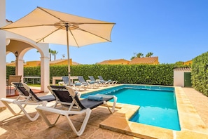 A pool area with lounge chairs and a large umbrella. - Villa Avellano by Villa Plus (Cap d'Artrutx)