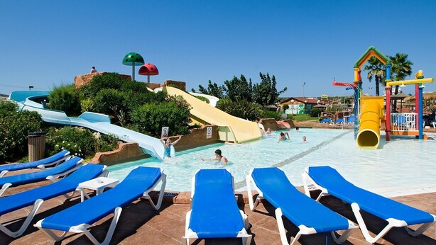 A pool area with multiple slides, lounge chairs, and a water play structure. - Villa Dolfi by Villa Plus (Los Delfines)