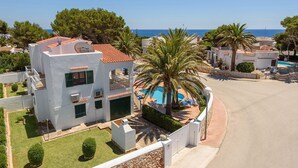 A modern villa with a pool, surrounded by palm trees and a clear view of the sea. - Villa Imogen by Villa Plus (Cap d'Artrutx)