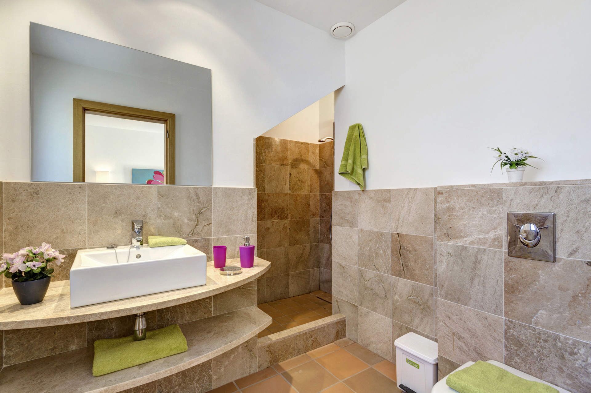 Un baño moderno con un lavamanos grande, una ducha y un inodoro.