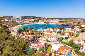 A coastal resort area with villas, a beach, and a marina. - Villa Las Mariposas by Villa Plus (Es Mercadal)