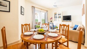 A dining area with a round wooden table set for four, surrounded by wooden chairs. - Villa Las Mariposas by Villa Plus (Es Mercadal)