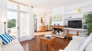 Een woonkamer met een televisie, bank en salontafel.