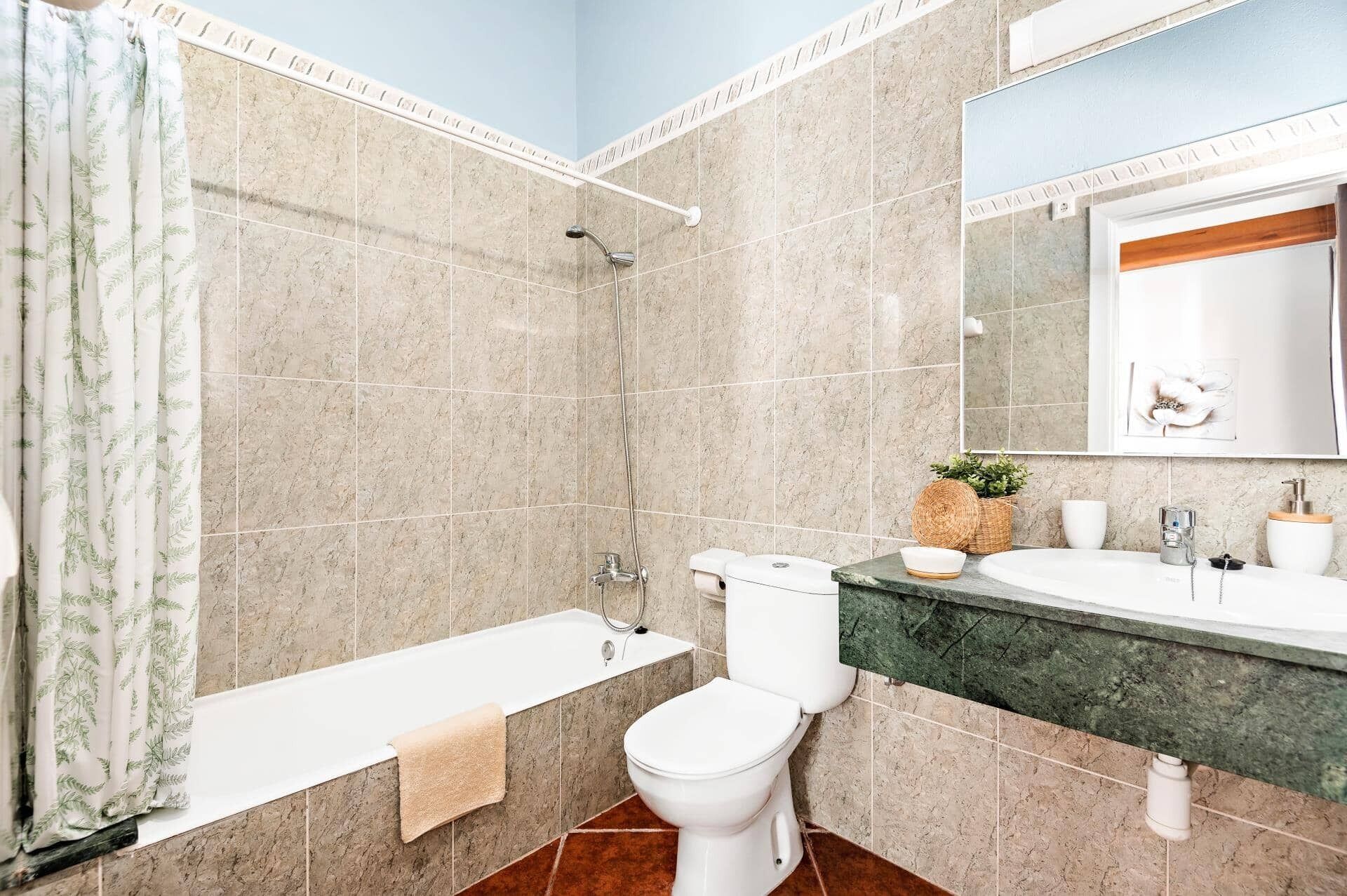 Un baño con bañera, inodoro y lavamanos.
