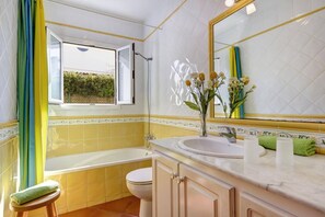 Une salle de bain avec une baignoire, des toilettes et un lavabo.