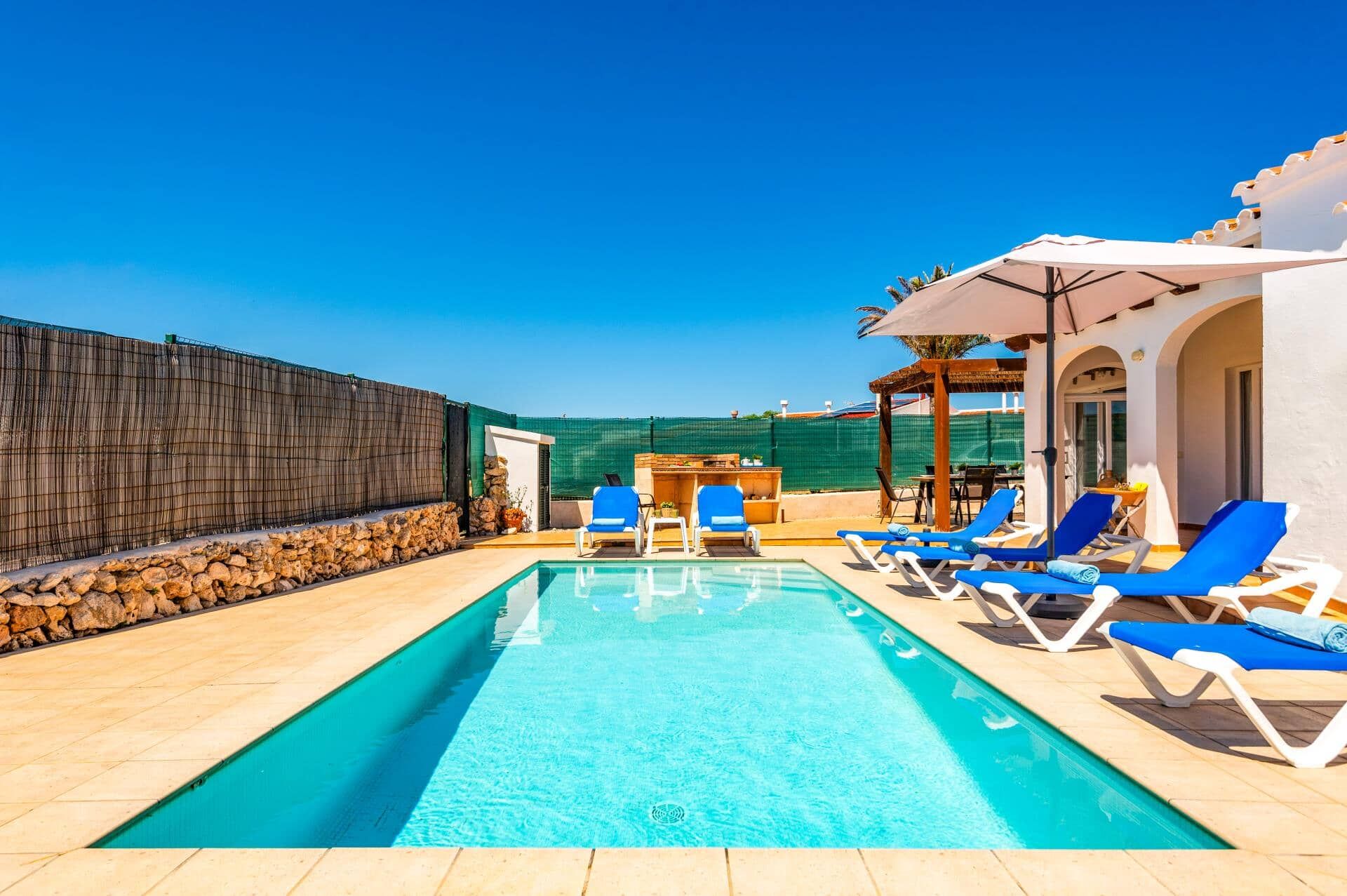 A swimming pool with lounge chairs and a bar area.