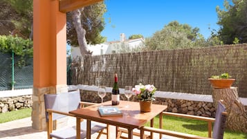 Relax on the patio surrounded by lush greenery and a serene view.