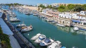 Un puerto deportivo con numerosos barcos amarrados a lo largo de la costa, rodeado de edificios de arquitectura tradicional.