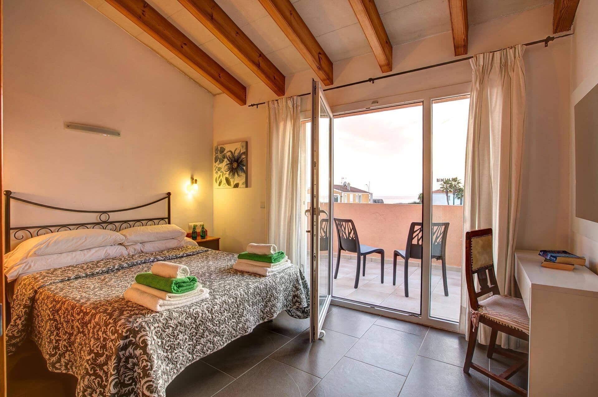 Un dormitorio con cama, escritorio y vistas al exterior.