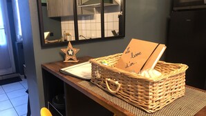 Une cuisine avec un plan de travail en bois, un panier en osier contenant une carte et une décoration en forme d’étoile.