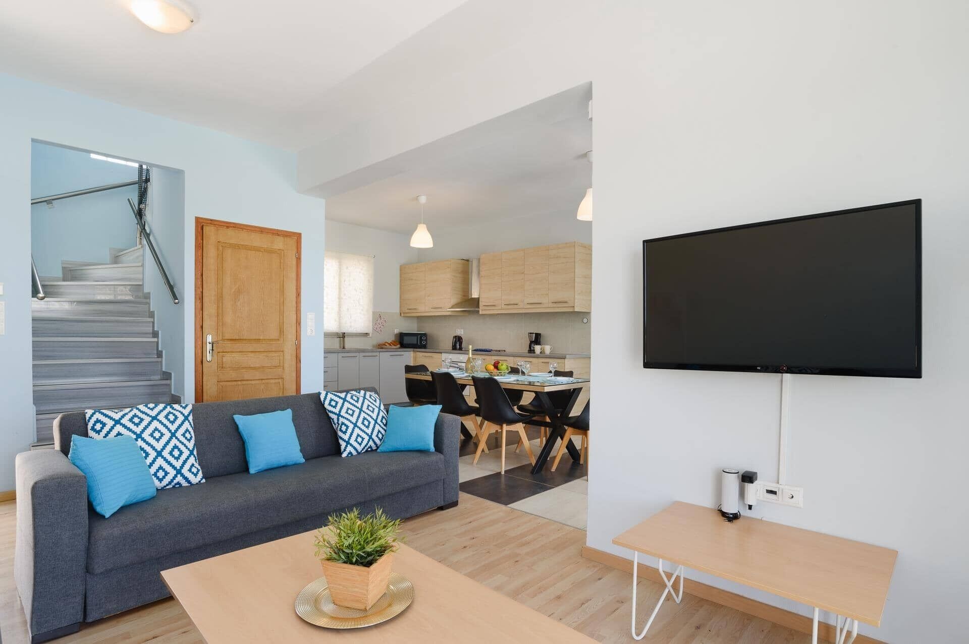 A modern living room with a sofa, coffee table, and a flat-screen TV.