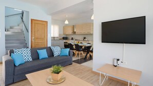 Una sala de estar moderna con sofá, mesa de centro y televisor de pantalla plana.