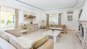 Un salon spacieux doté d’une cheminée, de sièges confortables et d’une grande fenêtre laissant entrer la lumière naturelle.