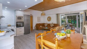 A modern kitchen with white cabinetry, a built-in oven, and a stainless steel refrigerator. - Villa Casa Calma by Villa Plus (Albufeira)