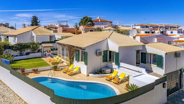 Eine moderne Villa mit Swimmingpool, Sitzgelegenheit im Freien und Blick auf die umliegende Nachbarschaft.