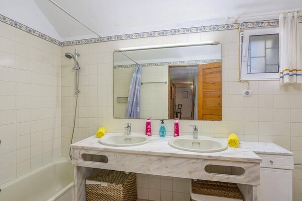 A bathroom with two sinks, a shower, a mirror, and a window. - Villa Pinheiro Oura by Villa Plus (Albufeira)