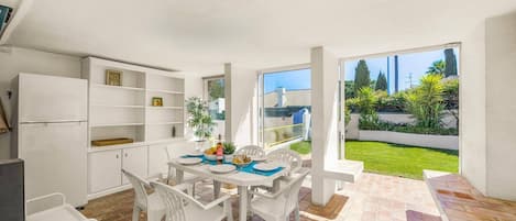 Enjoy meals in this kitchen and dining area with refrigerator, sink, and seating for four.