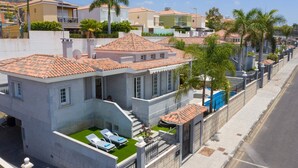 A residential area with houses featuring terracotta roofs and a swimming pool.