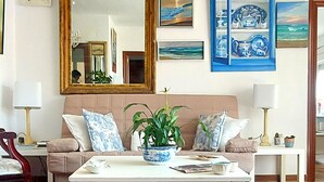 Un salon avec un canapé, une table basse et un grand miroir.