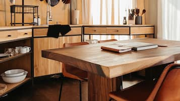 Una cocina moderna con armarios de madera, una gran mesa de madera y dos sillas de cuero.