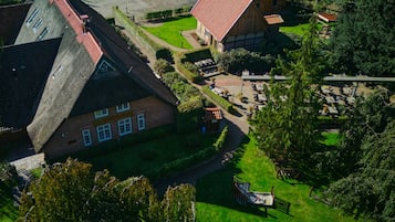 A traditional European-style building with a steeply pitched roof, surrounded by lush greenery and a well-maintained garden.