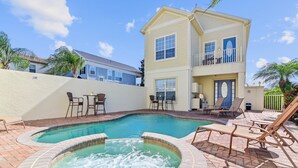 A two-story house with a swimming pool and hot tub, surrounded by patio furniture and palm trees. - Best Golf Course View, 6 mi from Disney! (Reunion)