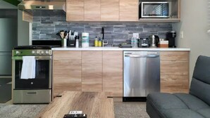A modern kitchen with wooden cabinets, a built-in microwave, a stainless steel dishwasher, and a vintage stove. - Urban Oasis to Love, Near SF, Free Parking Onsite (Hayward)