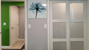 A hallway with a green wall, a white door, and a frosted glass door. - Urban Oasis to Love, Near SF, Free Parking Onsite (Hayward)