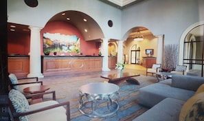 Welcome to our lobby, featuring a reception desk, comfortable seating, and a large window.