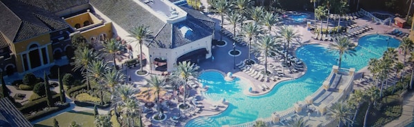 Relax by the resort's central pool surrounded by palm trees and lounge areas.