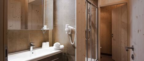 Ein modernes Badezimmer mit einem Holz-Waschtisch, einem großen Spiegel, einer Dusche und einer Toilette.