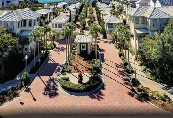 A residential area with rows of houses, a central landscaped area, and a paved walkway.