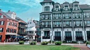 A historic building with multiple balconies and a tower, surrounded by a well-maintained lawn and other buildings. - Coastal Comfort,Spacious and Bright Condo right on 30A (Seacrest)