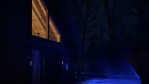 Een bubbelbad buiten een gebouw 's nachts, met een donkere omgeving.