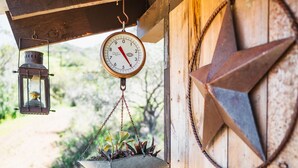 A wooden structure with a hanging planter, a lantern, and a metal star decoration.