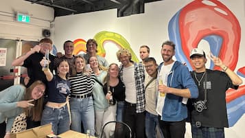 A group of people posing in front of a colorful mural with abstract designs.