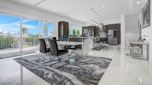A modern kitchen with dark cabinets, stainless steel appliances, and a large island. - P70 - Stunning 5 bed, 5 bath home with dockage and oversized private pool in Key Colony! (Key Colony Beach)