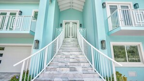A staircase leading to a door with a white railing, surrounded by light blue walls and white railings. - P70 - Stunning 5 bed, 5 bath home with dockage and oversized private pool in Key Colony! (Key Colony Beach)